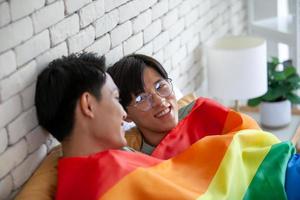 feliz pareja gay asiática hablando juntos y relajándose en casa en la cama, concepto lgbtq. foto