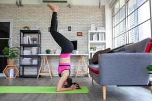 joven asiática haciendo ejercicio y haciendo yoga en casa, concepto saludable. foto