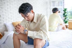 Asian gay couples are quarreling, angry or sad on bed in home,  LGBTQ concept. photo