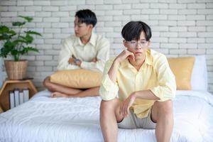 Asian gay couples are quarreling, angry or sad on bed in home,  LGBTQ concept. photo
