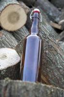 Glass bottle on wooden stack photo