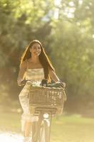 Young woman with flowers in the basket of electric bike photo