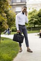 Young African American businessman using a mobile phone on a street photo