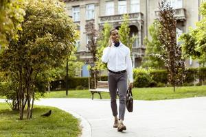 Young African American businessman using a mobile phone on a street photo
