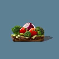 Healthy vegetables on round wooden board isolated on gray background. photo