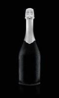 Black exquisite wine bottle covered with drops isolated on black background. photo