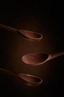 Wooden spoons on a dark brown background. Side view. photo