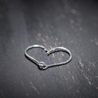 Heart-shaped fish hooks on a dark background. photo