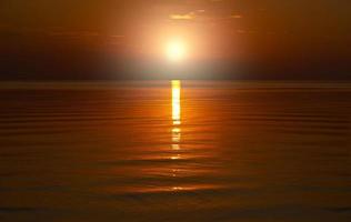Beautiful orange sunset is reflected in the sea. photo