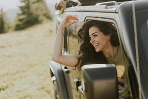 mujer joven que disfruta de la libertad en un vehículo todoterreno en un día soleado foto