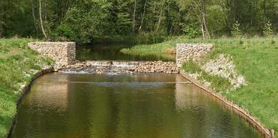 Artificial rapids of a quiet rive. Summer landscape. photo