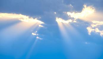 The sun's rays break through the blue clouds. The background of the sky. photo