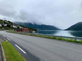 fiordos de noruega a lo largo de una carretera con un pueblo al borde del agua foto