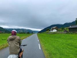 A cyclist tourist man riding on a road in Norway Fjords 1 photo