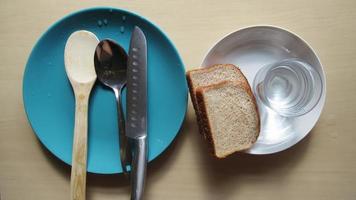 bread, water, plate, spoon, knife