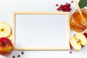 feliz rosh hashaná. marco para texto de felicitación. manzanas, granadas y miel sobre fondo blanco. judaísmo tradicional foto