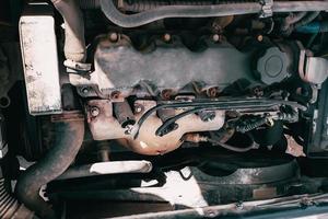 Open hood of the car. View of the engine and vehicle parts. Diagnostics and repair of old car. photo