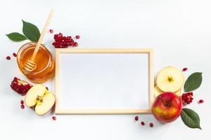 feliz rosh hashaná. marco para texto de felicitación. manzanas, granadas y miel sobre fondo blanco. judaísmo tradicional foto