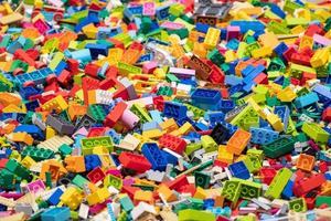 multicolor de muchos bloques de juguete lego en diferentes tamaños, vista superior. juguetes y juegos. ocio y recreación foto