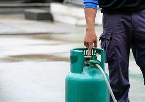 mano del hombre apuntando a la válvula abierta de gas lpg, demostración de protección contra incendios causada por el uso diario, planes de bomberos foto