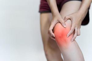 A woman's hand touches her knee due to pain.