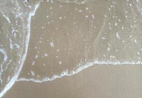 Sea waves on the surface of the sandy beach.Soft waves of blue sea. photo