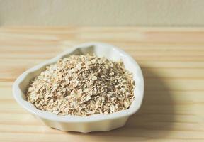 oat or granola in heart shape white bowl, ready for cooking. Healthy food  concept. photo