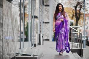 Indian hindu girl at traditional violet saree posed at street. photo