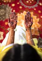 hermosa novia india que muestra el diseño mehndi de las manos. par de manos vista superior del diseño tradicional de henna en la mano de las novias. foto