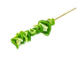 green chopped sweet bell pepper with wood skewer isolated on white background photo