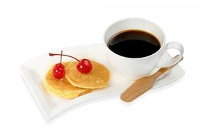 taza de café con tortitas y cerezas aisladas en fondo blanco, incluye ruta de recorte foto