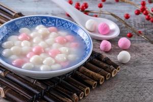 Close up of red and white tangyuan in blue bowl on wooden background for Winter solstice. photo