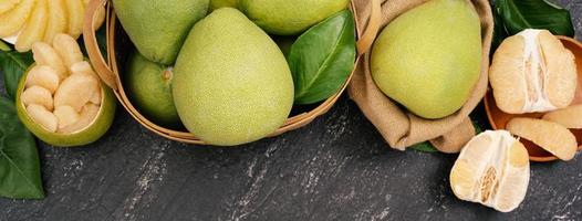 Fresh pomelo, pummelo, grapefruit, shaddock on black background, fruit for Mid-autumn festival, top view, flat lay. photo