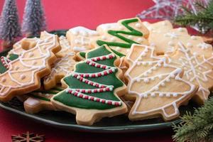 Close up of Christmas sugar cooikes in a plate on red table background. photo