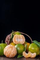 mandarina mandarina verde fresca sobre fondo de mesa de madera oscura. foto