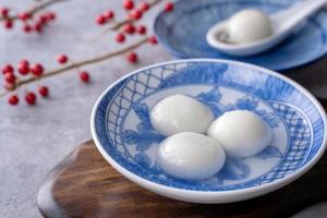 primer plano de tangyuan en un recipiente sobre una mesa gris, comida para el solsticio de invierno. foto