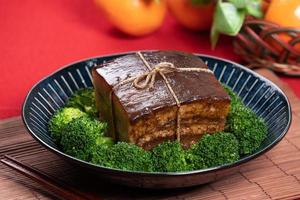 Dong Po Pork meat in a blue plate with broccoli with red background. photo