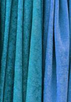 Detailed close up view on samples of cloth and fabrics in different colors found at a fabrics market photo