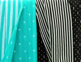 Detailed close up view on samples of cloth and fabrics in different colors found at a fabrics market photo
