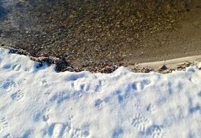 View over frozen lake with reflection of blue sky in clear weather. photo