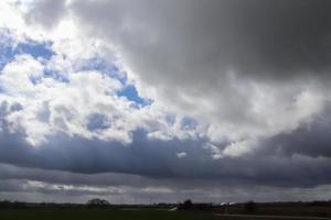 Beautiful clouds in a dark sky over a northern european landscape. photo