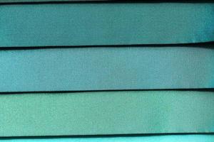 Detailed close up view on samples of cloth and fabrics in different colors found at a fabrics market photo