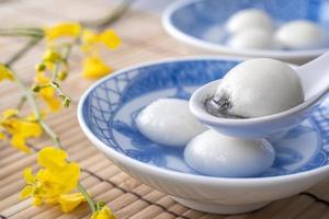 primer plano de tangyuan en un recipiente sobre una mesa gris, comida para el solsticio de invierno. foto