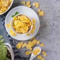 Corn flakes bowl sweets on gray cement background, top view flat lay layout design, fresh and healthy breakbast concept. photo