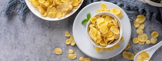 Corn flakes bowl sweets on gray cement background, top view flat lay layout design, fresh and healthy breakbast concept. photo