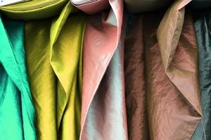 Detailed close up view on samples of cloth and fabrics in different colors found at a fabrics market photo