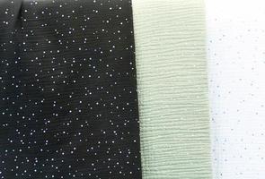 Detailed close up view on samples of cloth and fabrics in different colors found at a fabrics market photo