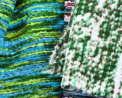 Detailed close up view on samples of cloth and fabrics in different colors found at a fabrics market photo