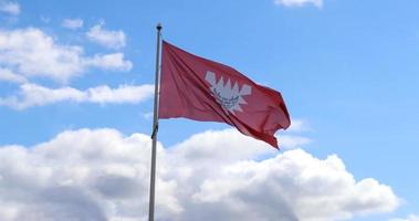 Kiel flag at a flagpole moving slowly in the wind against the sky photo