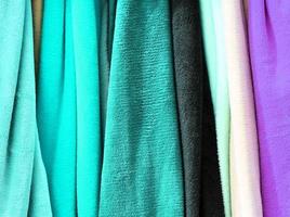 Detailed close up view on samples of cloth and fabrics in different colors found at a fabrics market photo